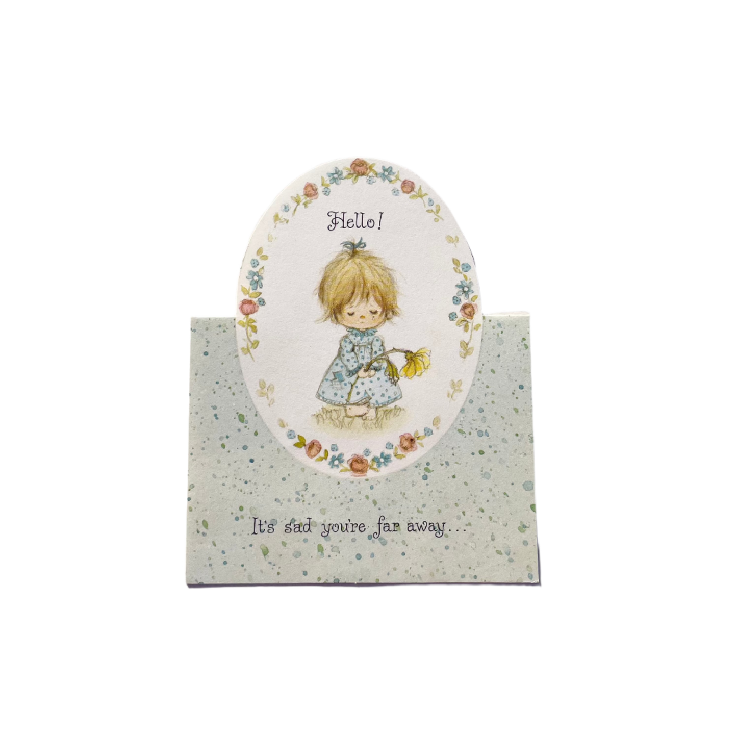 A vintage greeting card with a floral pattern and an illustration of a girl holding a flower saying 'Hello! It's sad you're far away.'