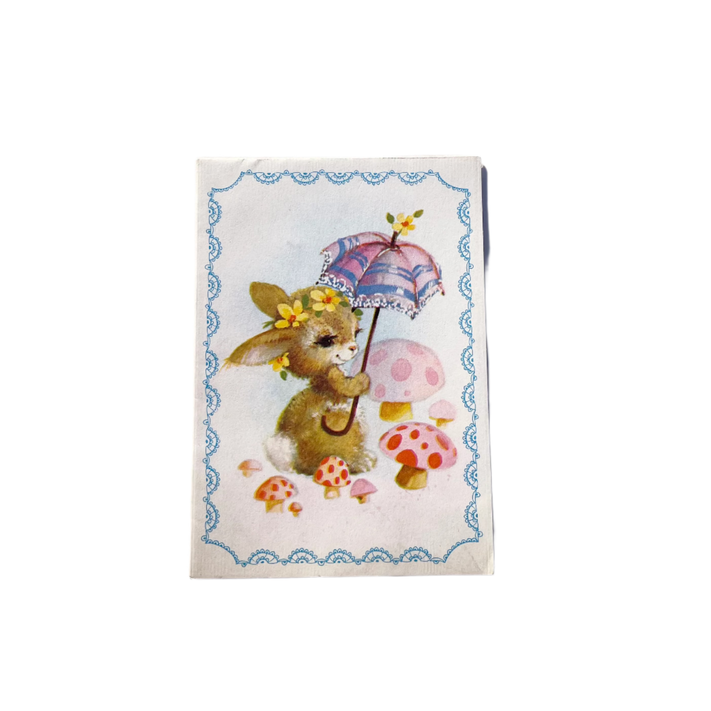 A vintage paper card depicting a stylized rabbit character with a floral crown and a parasol, surrounded by mushrooms and decorative elements.