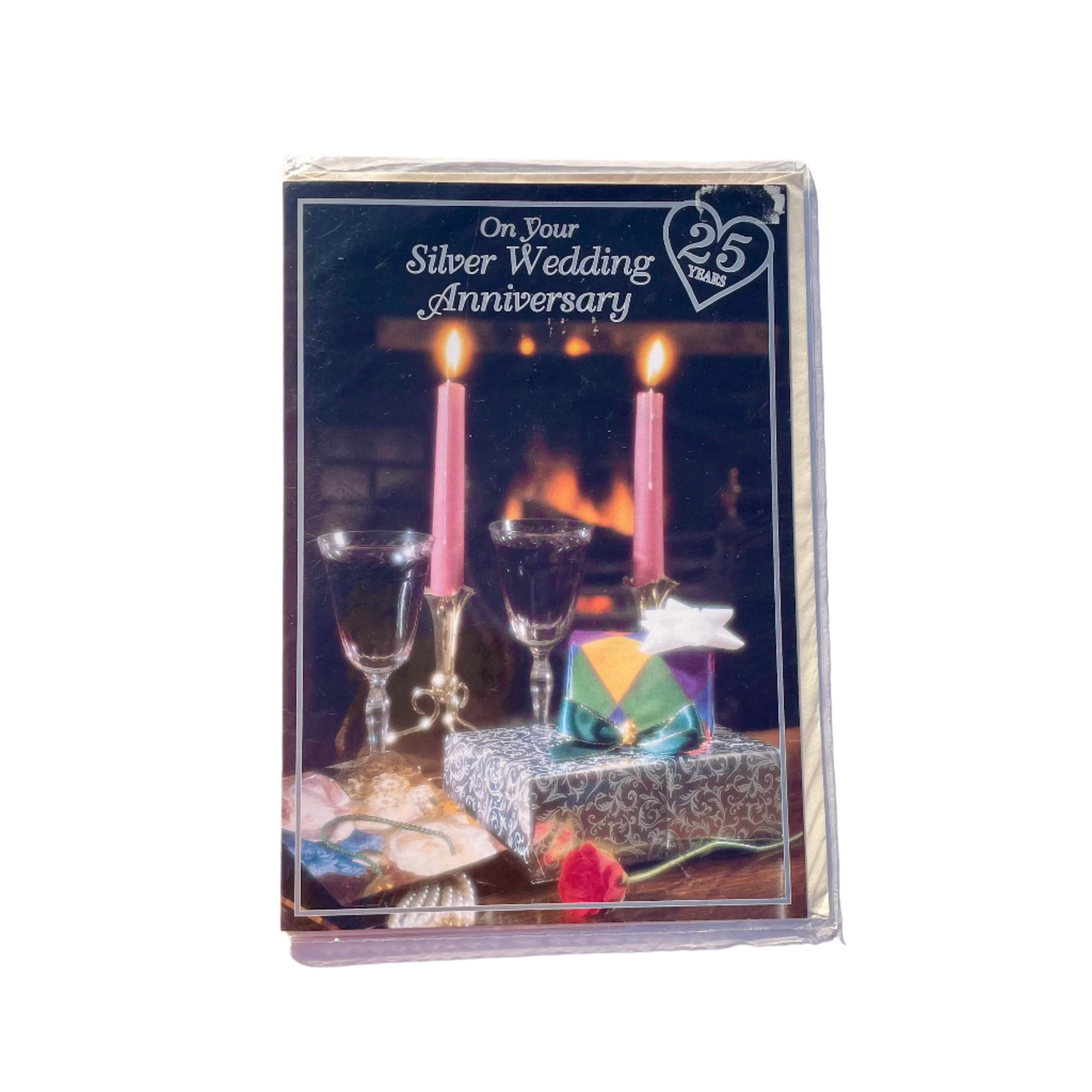 A greeting card for a Silver Wedding Anniversary that says 'On Your Wedding Anniversary' and '25 Years' in a love heart. Featuring an image of champagne glasses and candles in front of a fireplace.