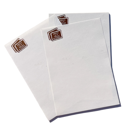 White writing paper sheets with a brown emblem  on the upper right corner saying 'MAGIC IS A TRICKY BUSINESS'.