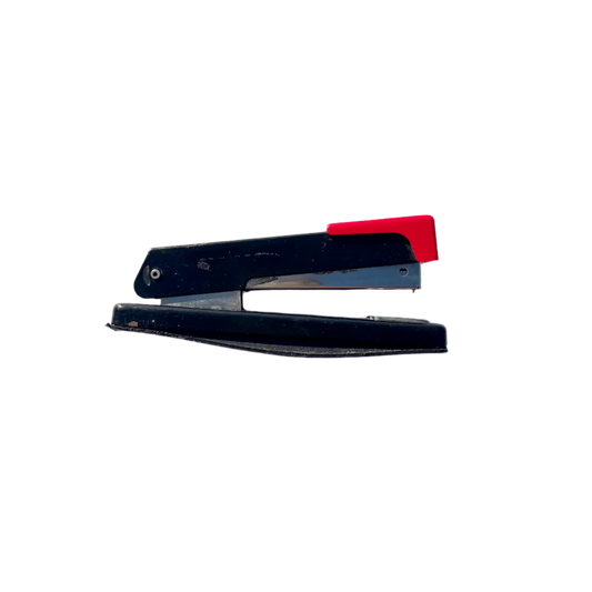A vintage black and red stapler with visible signs of wear and rust.