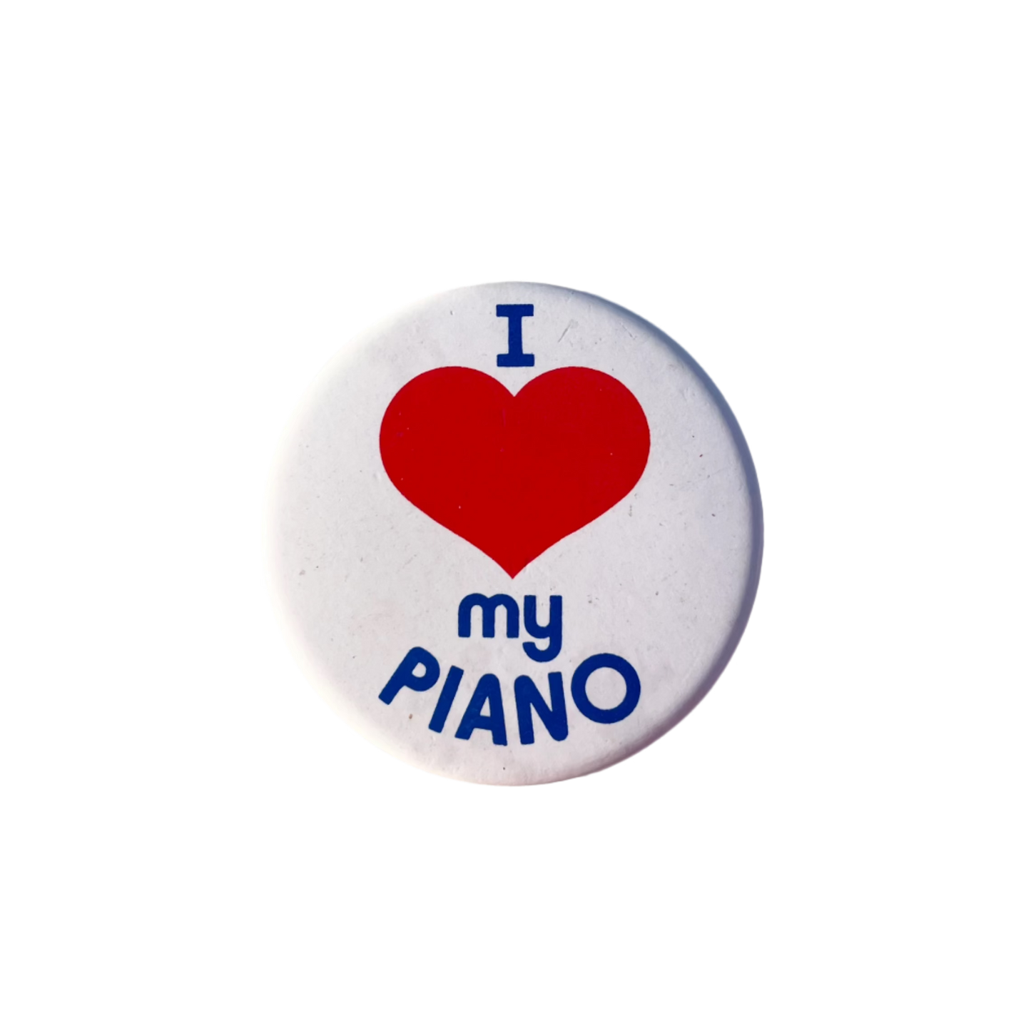 A badge with a red heart and the text 'I love my PIANO' in blue on a white background.