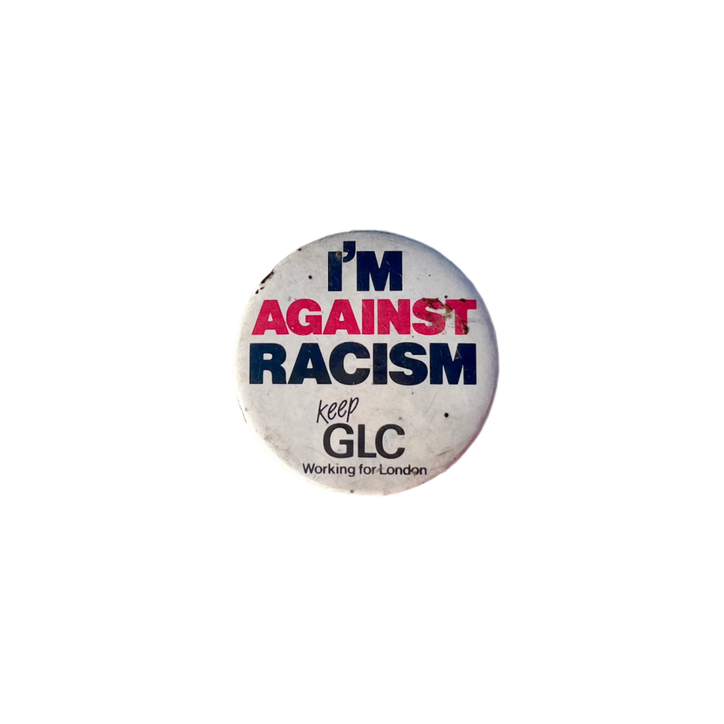 A round badge with the text 'I'M AGAINST RACISM' in black and red letters, with a smaller text 'keep GLC Working for London' in black on a white background.