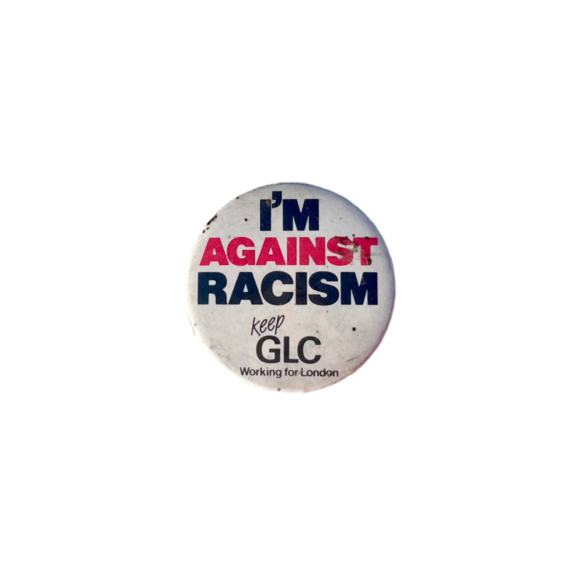 A round badge with the text 'I'M AGAINST RACISM' in black and red letters, with a smaller text 'keep GLC Working for London' in black on a white background.